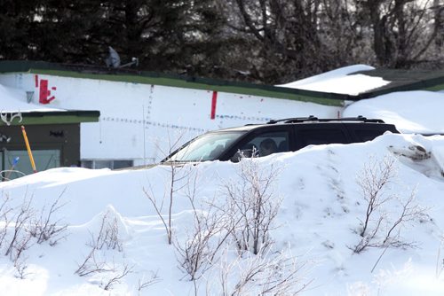 RCMP continue to investigate a death on a property on McGillivray Boulevard, between Kenaston Boulevard and McCreary Road. In this photo a suv with someone in it on the taped of area.  BORIS MINKEVICH / WINNIPEG FREE PRESS  March 10, 2014
