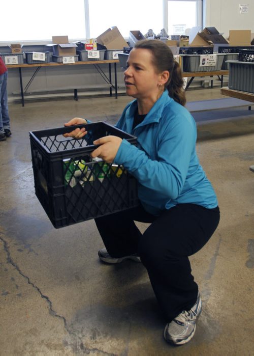 49.8 Training Basket.     Tammy Watson, Winnipeg Harvest's volunteer services coordinator does some exercises to keep fit.   Here  she does a some loaded squats with crate with canned goods..Ashley Prest story     Wayne Glowacki / Winnipeg Free Press March 10   2014