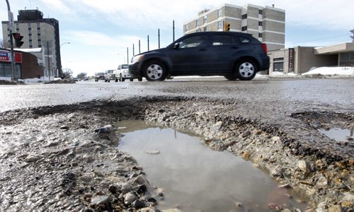 Potholes on Keewatin St. near Logan Ave. Monday  For infrastructure story  Wayne Glowacki / Winnipeg Free Press March 10   2014
