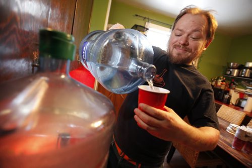 March 10, 2014 - 140310 -  Scott Wachal pours a cup of water from a 20 litre container at his Cathedral Avenue home Monday, March 10, 2014. Wachal's water pipes are frozen and he hasn't had water for two weeks. John Woods / Winnipeg Free Press
