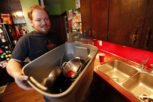 March 10, 2014 - 140310 -  Scott Wachal loads his dirty dishes into a container at his Cathedral Avenue home Monday, March 10, 2014. He is planning to bring his dishes over to a friends house to wash. Wachal's water pipes are frozen and he hasn't had water for two weeks. John Woods / Winnipeg Free Press