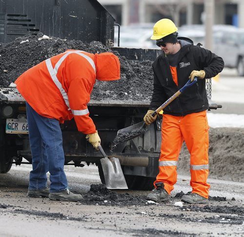Stdup City Pothole fixing crews are out all over the city repairing  damaged streets . In pic a crew is on St. James St.  Mar. 11 2014 / KEN GIGLIOTTI / WINNIPEG FREE PRESS
