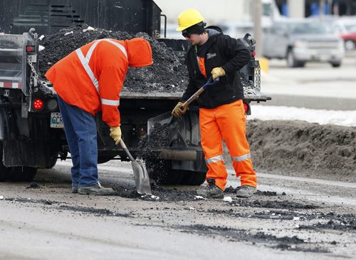 Stdup City Pothole fixing crews are out all over the city repairing  damaged streets . In pic a crew is on St. James St.  Mar. 11 2014 / KEN GIGLIOTTI / WINNIPEG FREE PRESS