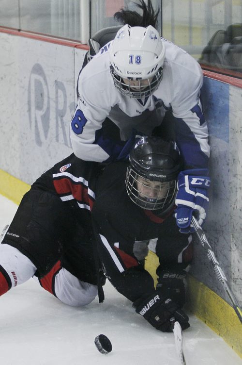 March 11, 2014 - 140311 -  Westwood Warriors' Alicia Prociuck (9) gets checked by Selkirk Royals' Ari Kowalchuck (18) in game 2 of the WWHSHL Division B final at MTS IcePlex Tuesday, March 11, 2014. Westwood Warriors tied the series 1-1.John Woods / Winnipeg Free Press