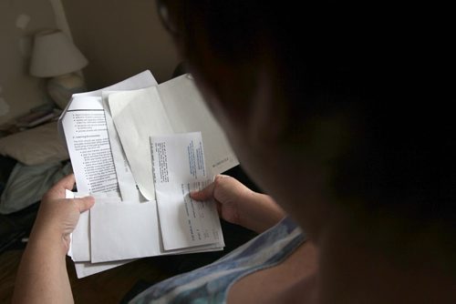 Our money makeover family looks at bills in her home-   See story- Mar 12, 2014   (JOE BRYKSA / WINNIPEG FREE PRESS)