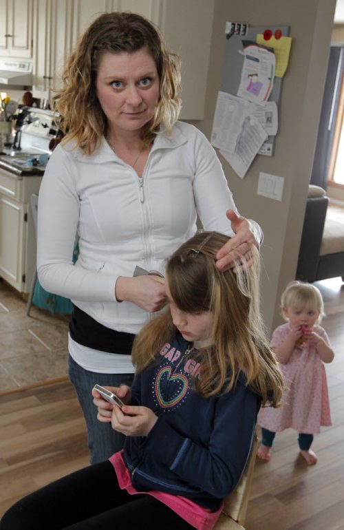 Sarah Phillips demonstrating her remedy to get rid of mutant lice. Shell be using her daughter. Shes got full time work, doing this: head by head. she lubricates with mint oil and picks the bugs and nits off strand by strand. BORIS MINKEVICH / WINNIPEG FREE PRESS  March 12, 2014 Louse