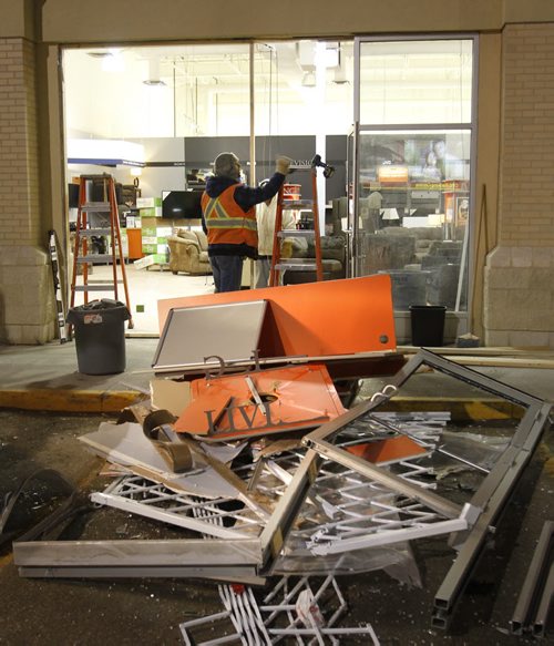 Workers board up the broken front window of the Easy Home store in a mall on Ellice Ave. at Empress St. Friday morning. (Media reports say a vehicle was driven through the front of the building, items were taken and vehicle was driven away.)  Wayne Glowacki / Winnipeg Free Press March 14   2014