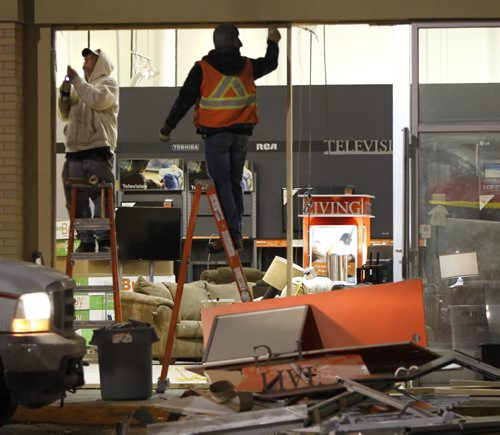 Workers board up the broken front window of the Easy Home store in a mall on Ellice Ave. at Empress St. Friday morning. (Media reports say a vehicle was driven through the front of the building, items were taken and vehicle was driven away.)  Wayne Glowacki / Winnipeg Free Press March 14   2014