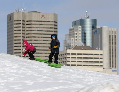 Stdup Chill'in & Tough Sledding   - minus 14 Temps haven't kept kids from sliding at the Forks  (right) David age 7 and (left) Elizabeth Sharp age 6 sliding with the skyline in the background - Mar. 14 2014 / KEN GIGLIOTTI / WINNIPEG FREE PRESS