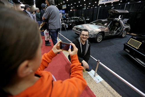 Angela Aluloska, 11, photographs her father Nik Aluloski in front of the Delorean from Back to the Future at the World of Wheels Car show at the Convention Centre, Saturday, March 15, 2014. (TREVOR HAGAN/WINNIPEG FREE PRESS) - different spelling of last names is correct.