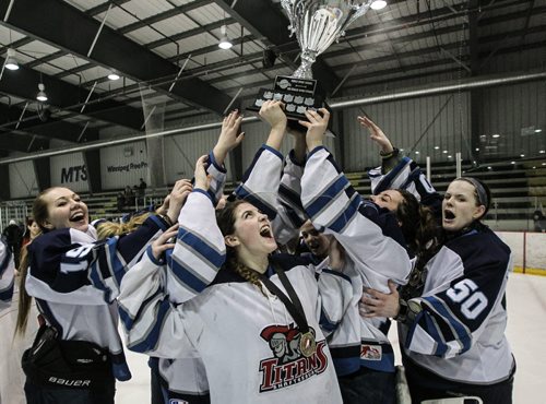 Justine Fredette (4) (centre) cheers and looks up at the trophy as her teammates gather around after winning the gold medal in the Female World School Challenge finals. Shaftesbury Titans and the Pursuit of Excellence played in the Female World School Challenge gold medal game at the MTS IcePlex Sunday afternoon. The Titans beat Kelownas' Pursuit of Excellence 5-2.  140316 - Sunday, March 16, 2014 -  (MIKE DEAL / WINNIPEG FREE PRESS)