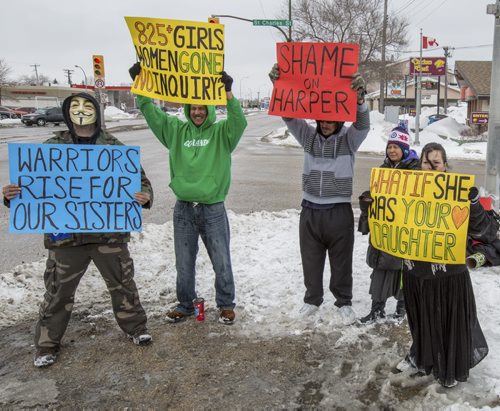 Demonstrators brave the cold and snow and gather on the corner of Portage Avenue and St. Charles Street in Winnipeg on Monday, March 17, 2014. They protested in hopes of prompting the Harper government into starting a national inquiry into, not just aboriginal but all, missing and murdered women. (Photo by Crystal Schick/Winnipeg Free Press)