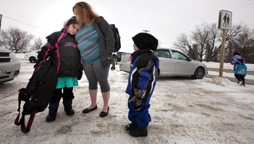 Sandra Ducharme, hugs her daughter Haylee (8),  Connor (6) watches  outside St Andrews School. Haylee was a class mate of and remembers playing with "Gracie" Herntier-Clark (?) who was killed by her family dogs over the weekend. See Geoff Kirbyson story. MArch 17, 2014 - (Phil Hossack / Winnipeg Free Press)