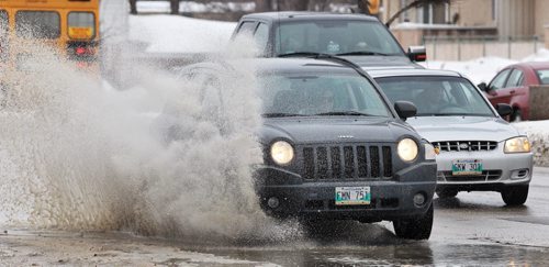 The wet season is just around the corner for those of you sick of the snowÄ¶ cars send up large sprays of water as they travel along Portage Avenue Monday afternoon.   140317 - March 17, 2014 MIKE DEAL / WINNIPEG FREE PRESS