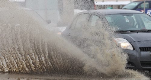 The wet season is just around the corner for those of you sick of the snowÄ¶ cars send up large sprays of water as they travel along Portage Avenue Monday afternoon.   140317 - March 17, 2014 MIKE DEAL / WINNIPEG FREE PRESS