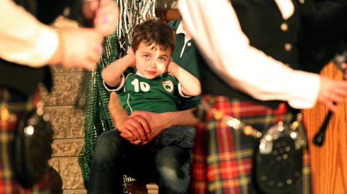 It's an "aquired" taste......three year old Cian Everett covers up as the Erin Street Pipe band performs Monday night at the Irish Club. St Patrick's day festivities at the club included an Irish Buffet, dancing, traditional music and lots of Guiness... March 17, 2014 - (Phil Hossack / Winnipeg Free Press)