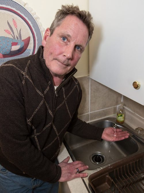 Todd Kerr, whose water pipes were frozen for 17 days and thawed by themselves, is upset and frustrated at the City's response to his request to run his water, as the City suggested, so his pipes don't freeze again in Winnipeg on Monday, March 17, 2014. Kerr was told that the City would not reimburse him his water cost if he continually runs his water, as they are for other residents, because his pipes were not thawed by the City. (Photo by Crystal Schick/Winnipeg Free Press)