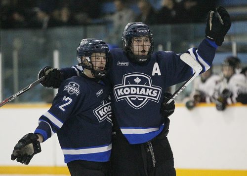 March 17, 2014 - 140317  -  River East Kodiaks Holden Band (12) and Tristan Beach (17) celebrate Beach's goal against the St Paul's Crusaders in the AAAA Provincial High School Hockey Championship at St James Arena, March 17, 2014. John Woods / Winnipeg Free Press