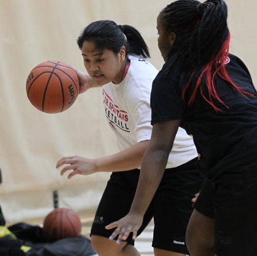 Sisler High's  Tiara Licsi (in white) works around Kyanna Giles at a team workout Tuesday evening. See Ed Tait story. March 18, 2014 - (Phil Hossack / Winnipeg Free Press)