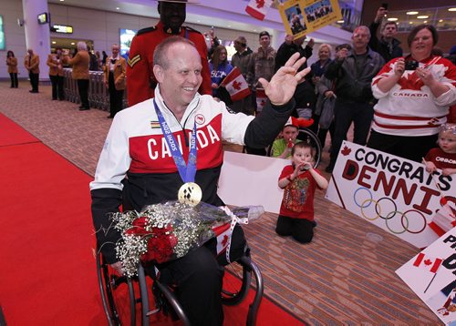 March 18, 2014 - 140318  -  Dennis Thiessen, gold medal curling Paralympian, waves as he is greeted by family and friends as he arrives at Winnipeg Airport Tuesday, March 18, 2014. John Woods / Winnipeg Free Press