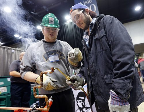 (right) Andrew Jones  age 21 is intersted in pumbing or welding , he is  soldering a copper pipe with Ryan Gillespie (left ) from Piping Industry Technical College display at the  Your Future Trending @ Rotary Career Symposium at the RBC Convention Centre Winnipeg in it's 17th year  and 131 schools participating with thousands of students  and adults attending , story by ashley prest Mar. 19 2014 / KEN GIGLIOTTI / WINNIPEG FREE PRESS