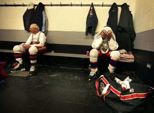 77 yr old Jim Nykoluk relaxes after an hour long scrimmage while Gerard McDonald (56) rests his head in his hands as he wipes the sweat off. See story. March 11, 2014 - (Phil Hossack / Winnipeg Free Press)