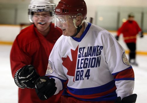 Jim Nykoluk (77 in white) celebrates a break away goal with Wayne Viznaugh (67) at River Heights Corydon Community Center for an afternoon scrimmage. It does't matter that one plays for the red the other the white team!  See story. March 4, 2014 - (Phil Hossack / Winnipeg Free Press)