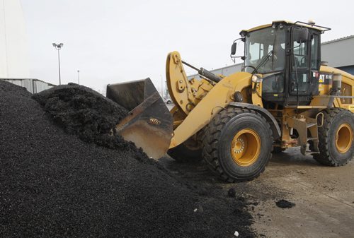 Saturday Special.  In the city yards,  a frontend loader picks up a bucket of "cold mix" to be loaded in the Transporter and taken to fill pot holes .     Kevin Rollason story Wayne Glowacki / Winnipeg Free Press March 20   2014