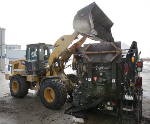 Saturday Special.  In the city yards,  a bucket of "cold mix" is poured into the Transporter that will be taken to fill in potholes.     Kevin Rollason story Wayne Glowacki / Winnipeg Free Press March 20   2014