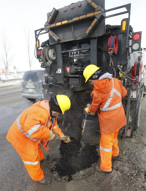 Saturday Special. City crews apply "cold mix" from the Transporter  into a pothole on Empress St. on a day with  below freezing temperatures.     Kevin Rollason story Wayne Glowacki / Winnipeg Free Press March 20   2014