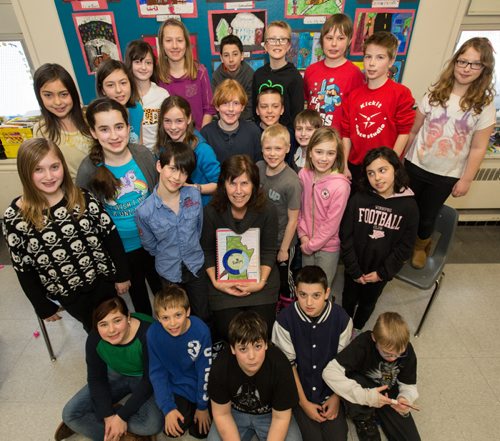 Fifth and sixth grade teacher at Brock Corydon School, Susan Pereles, shows of the book her class made for the project they created called ìCî Winnipeg,  which contains 23 positive ëCí words about the city in Winnipeg on Thursday, March 20, 2014. In partnership with Tourism Winnipeg and Take Pride Winnipeg, her classes have become ìchild ambassadorsî by studying the history, culture and unique aspects that make them proud to be from Winnipeg. (Photo by Crystal Schick/Winnipeg Free Press)