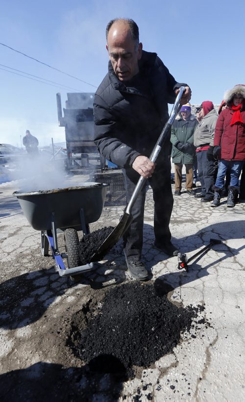 Pot Hole Repair -  Thunder Bird Restaurant,Pellet Patch sales rep Saverio Marra director of sales demonstrates  pot hole reapair technology using asphalt and rubber     and  the effectiveness of a rubber and asphalt  hot-mix-asphalt patching compound that had good results in Flint, Mich. Mar. 21 2014 / KEN GIGLIOTTI / WINNIPEG FREE PRESS