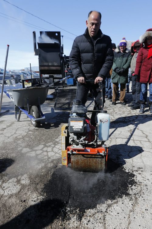 Pot Hole Repair -  Thunder Bird Restaurant,  Pellet Patch sales rep Saverio Marra director of sales demonstrates uses roller over freshly laid down hot  mixture,   pot hole reapair technology using asphalt and rubber     and  the effectiveness of a hot-mix-asphalt patching compound that had good results in Flint, Mich. Mar. 21 2014 / KEN GIGLIOTTI / WINNIPEG FREE PRESS