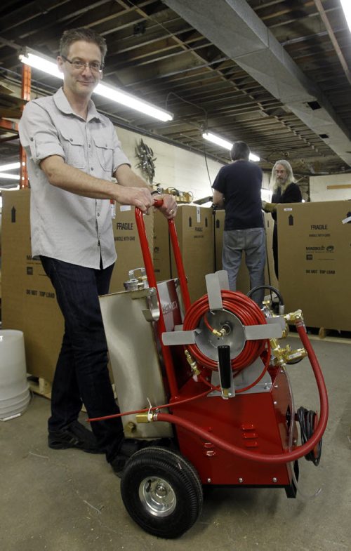 Micah Cohen owner of Magikist with one of their Pulse Jet De-Icers used to thaw frozen pipes is ready to be boxed and shipped out with other units in back. Aldo Santin story   Wayne Glowacki / Winnipeg Free Press March 21   2014