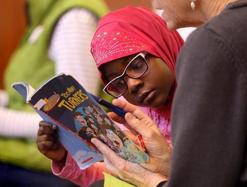 Six year old Yusrah Oaledji reads along with one of the volunteer lawyers at West Broadway Youth Outreach during the Lawyers Helping Kids Read Literacy event Saturday.  March 22, 2014 Ruth Bonneville / Winnipeg Free Press