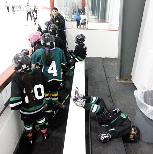 Norwway House's Aiden Moritz loses his balance and falls off the back of the bench during the teams Novice game against Cross Lake during the 27th Annual Aboriginal Minor Hockey Tournament at MTS Iceplex, Saturday, March 22, 2014. Fifty-seven teams from more than 10 communities are represented. (TREVOR HAGAN/WINNIPEG FREE PRESS)