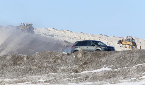 Dozers continue to pile snow at a dump site near Wilkes and the West Perimeter, Sunday, March 23, 2014. (TREVOR HAGAN/WINNIPEG FREE PRESS)