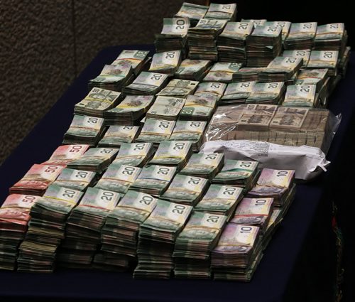 Police Display cash -A police traffic stop has resulted in the forfeiture  of $960,000 that will be used by law enforcement and victim services  under the Criminal Forfeiture Fund  as announced by Justice Minister Andrew Swan at RCMP HQ in Wpg .Mar. 24 2014 / KEN GIGLIOTTI / WINNIPEG FREE PRESS