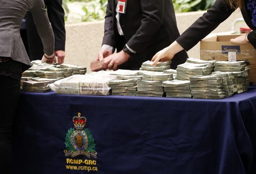 Police dispaly Cash as newser -.A police traffic stop has resulted in the forfeiture  of $960,000 that will be used by law enforcement and victim services  under the Criminal Forfeiture Fund  as announced by Justice Minister Andrew Swan at RCMP HQ in Wpg .Mar. 24 2014 / KEN GIGLIOTTI / WINNIPEG FREE PRESS