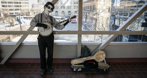 Chris Crossroads busks on the skywalk over Graham Avenue near WInnipeg Square Tuesday morning. The artist and musician plays the banjo regularly as a busker before Jets' games and midday for the tamer business crowd. 140325 - Tuesday, {month name} 25, 2014 - (Melissa Tait / Winnipeg Free Press)