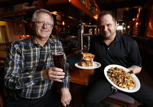 Xtra - Fox & Hounds Where: Fox & Hounds Tavern, 1719 Portage Ave. (St. James Hotel) LtoR  Owner Lawrence Maksymetz ,  Lee Poworoznik (manager) holding Sheapards Poutine  and Wolf Hound Burger ,  a Sunday This City piece; Fox & Houndshas been around for 90-odd years - current ownership group is celebrating its 25th anniversary at the helm, this year  holding up one of theirsignature burgers (one of them is a half-pound patty inside a grilled cheese sandwich) - probably behind the bar. The Fox & Hounds has a Cheers-type bar - right smack dab in the middle of the room. Lots of fox paraphernalia around, too - the owner went on a shopping trip to Britain after buying the place, and came back with all sorts ofcentury-old knick knacks and paintings... so whatever .Story by Dave Sanderson Mar. 25 2014 / KEN GIGLIOTTI / WINNIPEG FREE PRESS