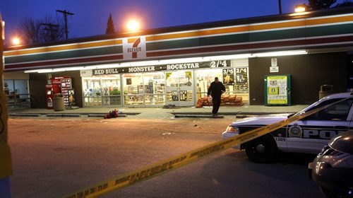 A Police officer in the taped off parking lot of the 7 Eleven store on Main Street at Bannerman Ave. Wednesday morning after a reported stabbing incident. A section of sidewalk on Main St. just south of the store is also taped off.    Wayne Glowacki / Winnipeg Free Press March 26   2014