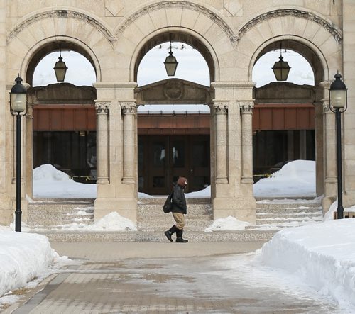 A man walks briskly past the St. Boniface Cathedral in Winnipeg on Wednesday, March 26, 2014. While finally warming up a bit, the weather still remained in the minus temperatures and below average for the year. (Photo by Crystal Schick/Winnipeg Free Press)