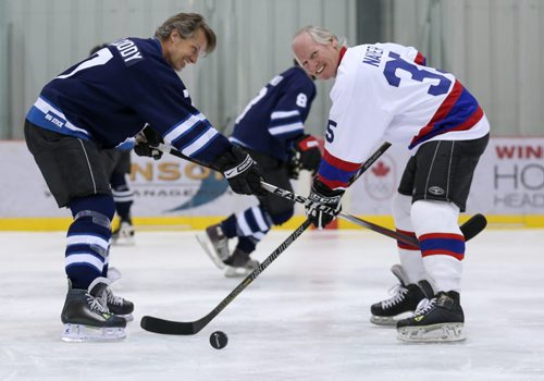Jim Cuddy, left, captain for the Rockers, and Mark Napier, captain for the NHLers, joke around as they pose for face-off at their practice for the Juno Cup at the MTS Iceplex in Winnipeg on Thursday, March 27, 2014. (Photo by Crystal Schick/Winnipeg Free Press)