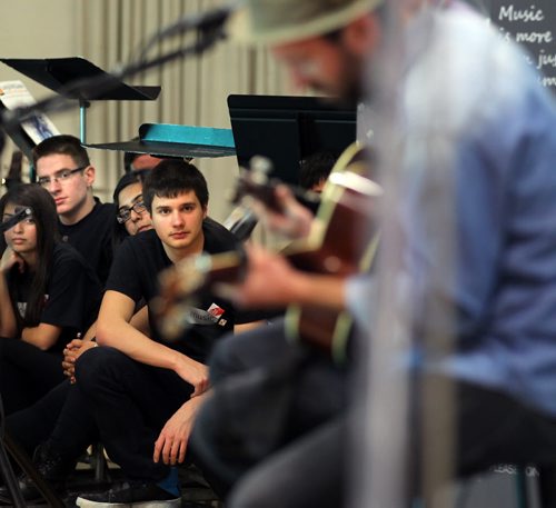 Musicians from the Maples Collegiate Jazz Band peer out from underneath their music stands while they follow the Trews in a concert and presentation at Maples Collegiate Friday afternoon. See story/Release March 28, 2014 - (Phil Hossack / Winnipeg Free Press)  . BAND AID GRANTS ON MARCH 28  CANADIAN ROCKERS THE TREWS SET TO PERFORM LIVE FOR STUDENTS  DETAILS: MusiCounts continues to keep music alive in schools across Canada teaming up with Canadian rockers, The Trews, to present two local Winnipeg schools (Maples Collegiate and Lakewood School) with their 2014 Band Aid Grant of $10,000 each to fund their  music education programs. Colin MacDonald and John-Angus MacDonald of The Trews, will present the students with instruments purchased with the grant and will treat them to an exclusive acoustic performance. MusiCounts will also recognize the over $1,000,000  contributed to date through Sirius XM Canada.  Special guest speakers include Director of MusiCounts, Allan Reid; Andreanne Sasseville, Director CCD and Industry Relations, from Sirius XM and Minister of Canadian Heritage and Official Languages, The Honourable Shelly Glover.