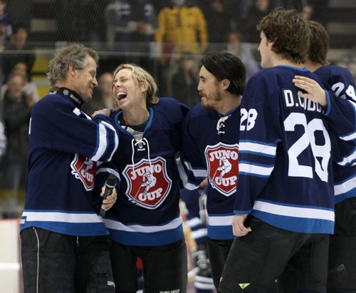 Canadian rock star Jim Cuddy, left has a laugh with Amanda Rheaume as they and others on Team Rockers sing Oh Canada before play Friday night against Team NHL Greats at the 11th annual Juno Cup at MTS iceplex Friday night-   Juno Standup- Mar 28, 2014   (JOE BRYKSA / WINNIPEG FREE PRESS)