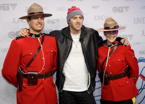 2014 Juno Awards host, and nominee for rap recording of the year and single of the year, Classified gets comfortable with two members of the RCMP on the Juno red carpet at MTS Centre in Winnipeg. (Joe Bryksa/ Winnipeg Free Press)