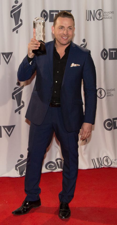 Johnny Reid kisses his 2014 JUNO for Adult Contemporary Album of the Year for the album A Christmas Gift to You at the 2014 JUNOs at the MTS Centre in Winnipeg on Sunday, March 30, 2014. (Photo by Crystal Schick/Winnipeg Free Press)