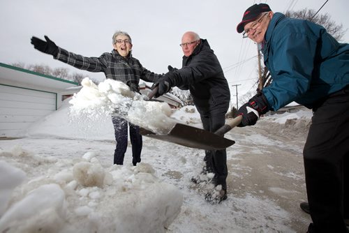 March 31, 2014 - 140331  -  Susan McVarish (L) cheers as Murray Greenley (C) and Delbert Comberbach clean up the last remaining ice of the windrow left by snow plows in the backland behind her garage at her East Kildonan home Avenue Monday, March 31, 2014. John Woods / Winnipeg Free Press