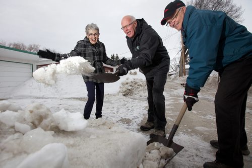 March 31, 2014 - 140331  -  Susan McVarish (L) cheers as Murray Greenley (C) and Delbert Comberbach clean up the last remaining ice of the windrow left by snow plows in the backland behind her garage at her East Kildonan home Avenue Monday, March 31, 2014. John Woods / Winnipeg Free Press